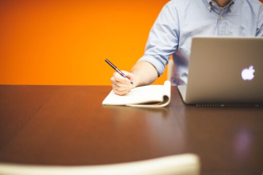 Jonge ondernemer aan bureau met laptop en notitieblok