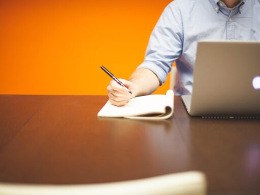 Jonge ondernemer aan bureau met laptop en notitieblok