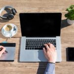 Zelfstandige ondernemer die thuis aan een bureau werkt met laptop en notitieboek