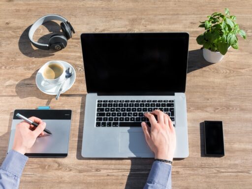Zelfstandige ondernemer die thuis aan een bureau werkt met laptop en notitieboek