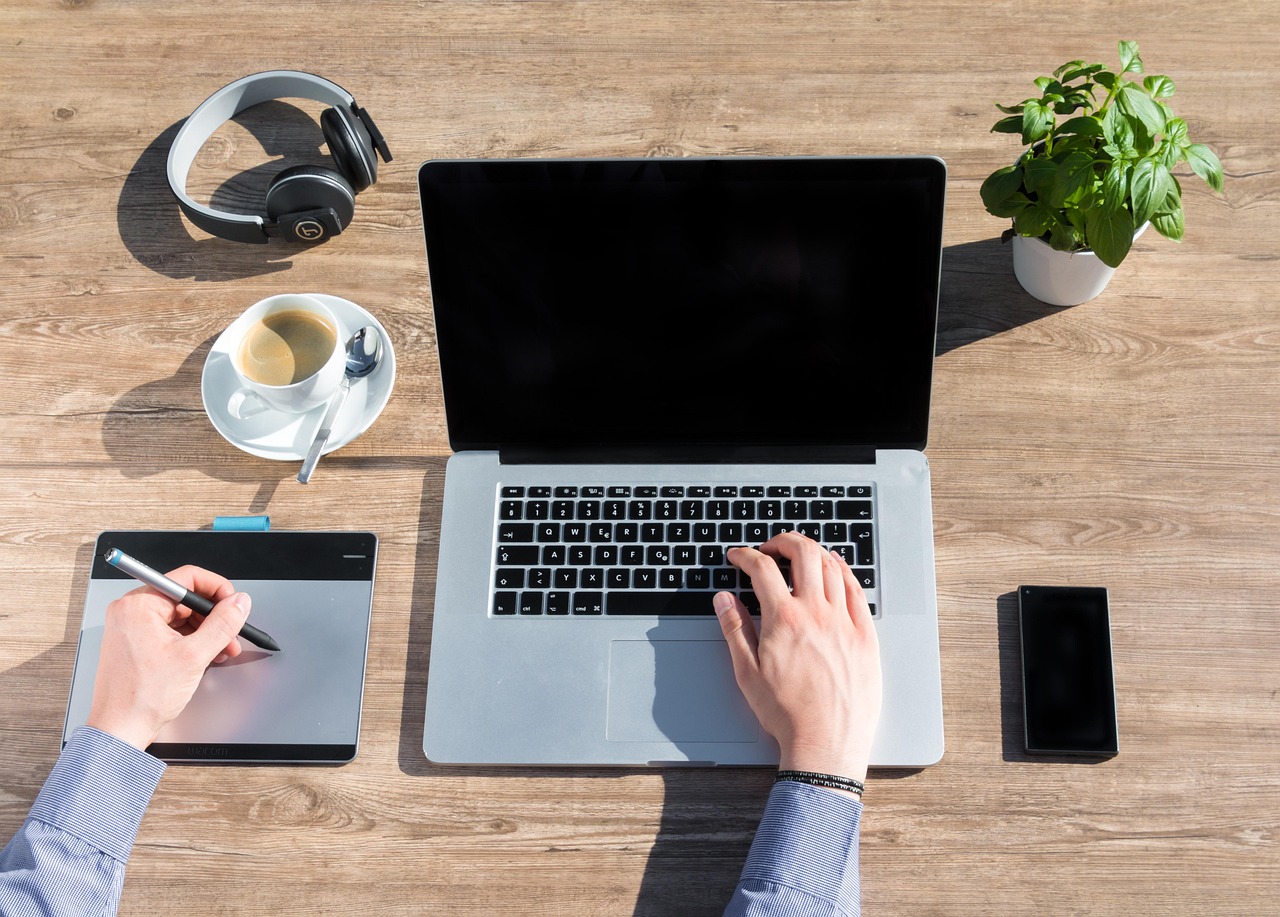 Zelfstandige ondernemer die thuis aan een bureau werkt met laptop en notitieboek