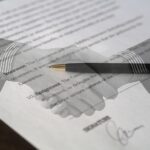 Twee zakenmensen schudden handen bij het ondertekenen van een internationaal handelscontract