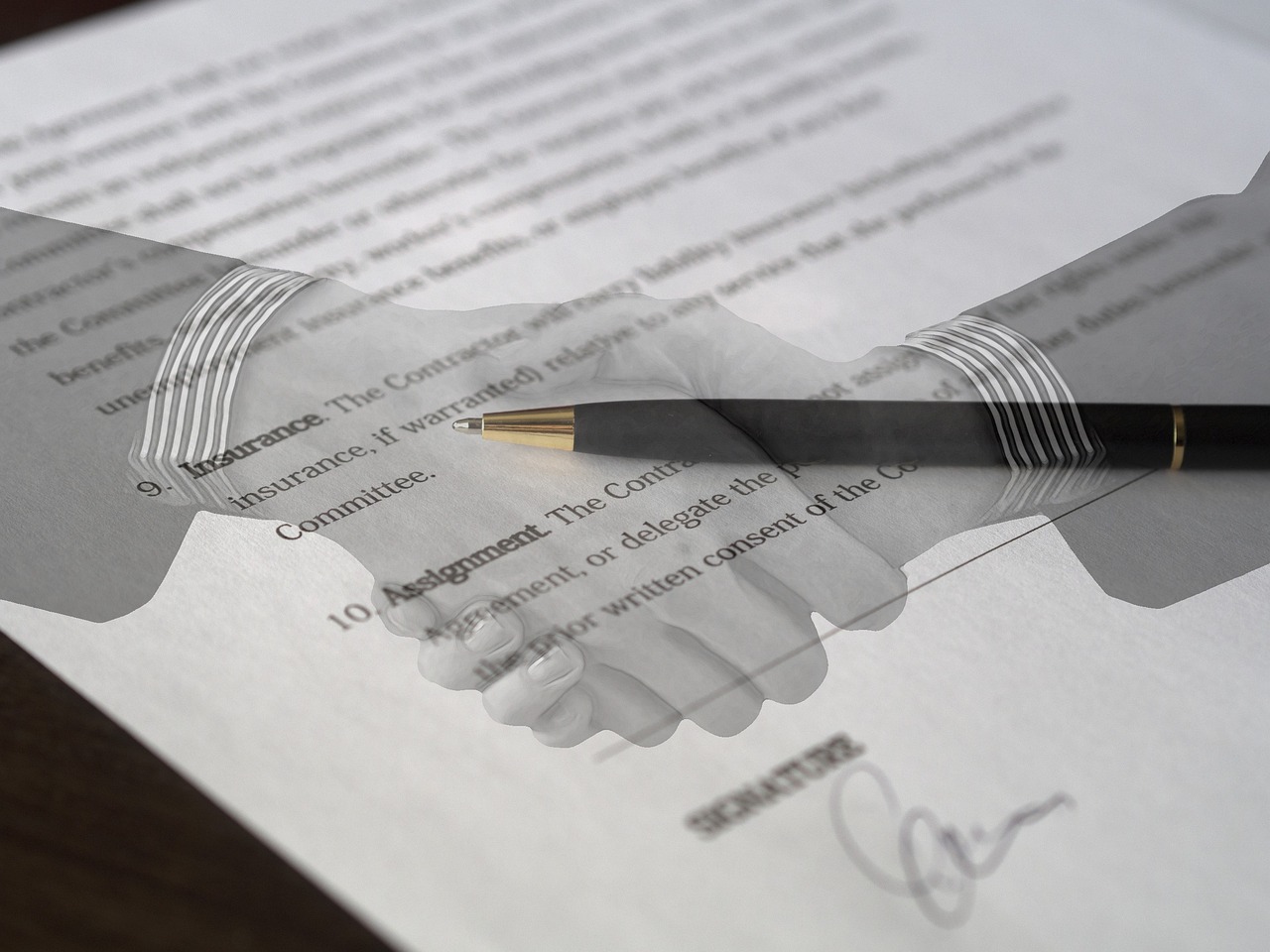 Twee zakenmensen schudden handen bij het ondertekenen van een internationaal handelscontract