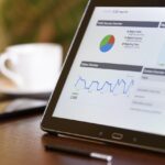 Ondernemer analyseert klantgegevens op laptop aan bureau