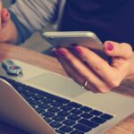 Accountant die op een laptop werkt aan zijn LinkedIn-profiel in een kantooromgeving