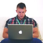 Zzp'er werkt aan laptop aan zijn bureau terwijl hij een onderaannemer inhuurt voor een opdracht