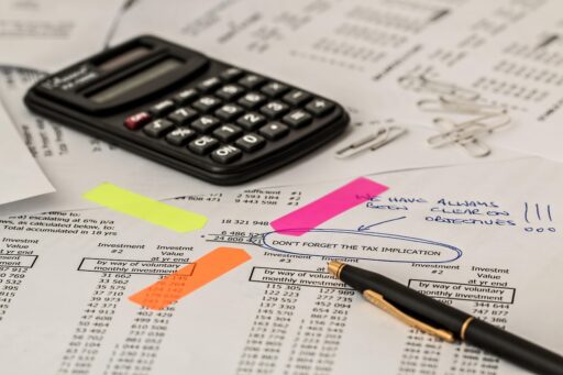 Starter aan bureau rekent met calculator en papieren voor belastingaangifte