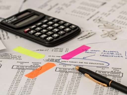 Starter aan bureau rekent met calculator en papieren voor belastingaangifte