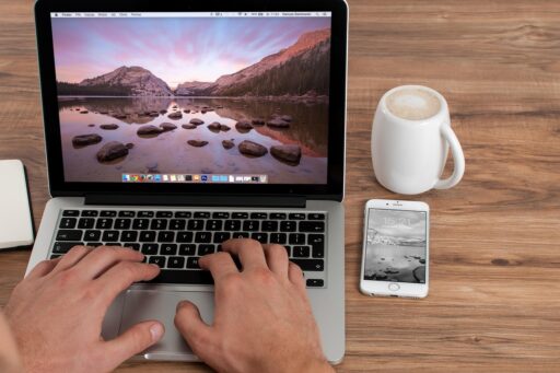 Zelfstandige ondernemer werkt op laptop in café en vergelijkt opties voor lidmaatschap