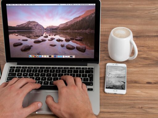 Zelfstandige ondernemer werkt op laptop in café en vergelijkt opties voor lidmaatschap