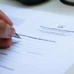 Ondernemer die een Engelstalig zakelijk contract doorleest aan een bureau