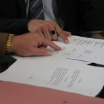 Mkb-ondernemer die een inleencontract doorleest en ondertekent op kantoor