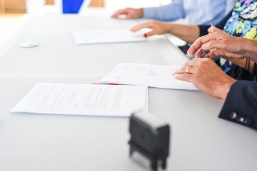 Ondernemer en medewerker bespreken en ondertekenen beleidsdocumenten aan een vergadertafel