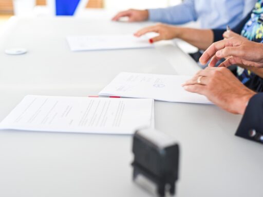 Ondernemer en medewerker bespreken en ondertekenen beleidsdocumenten aan een vergadertafel