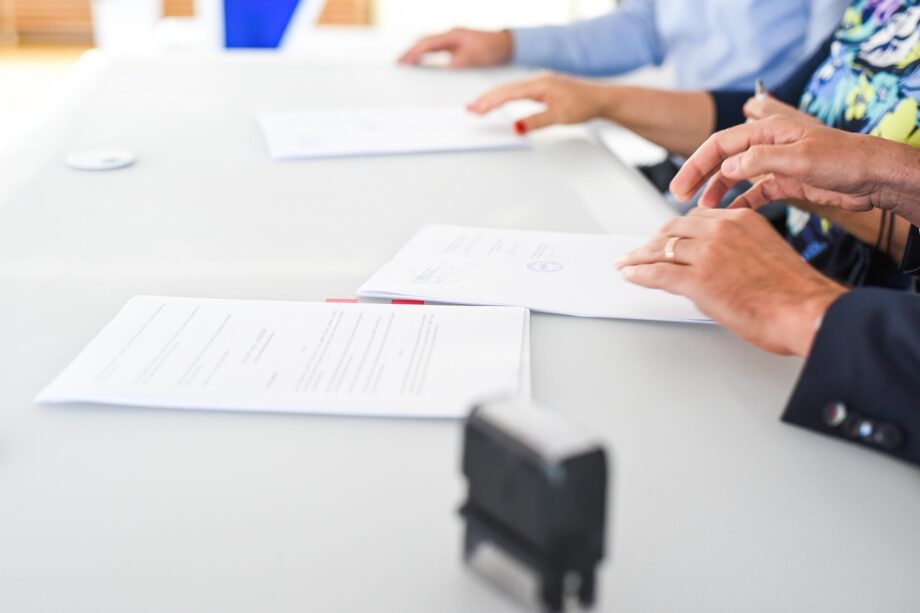 Ondernemer en medewerker bespreken en ondertekenen beleidsdocumenten aan een vergadertafel