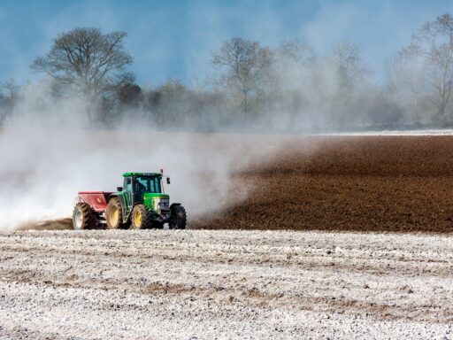 Boer op een tractor rijdt over een agrarisch perceel