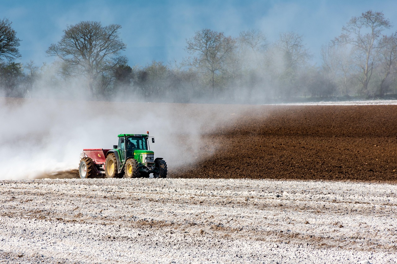 Boer op een tractor rijdt over een agrarisch perceel